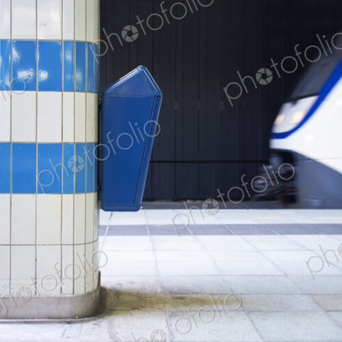 Waste bin on a platform pillar in a railway station.