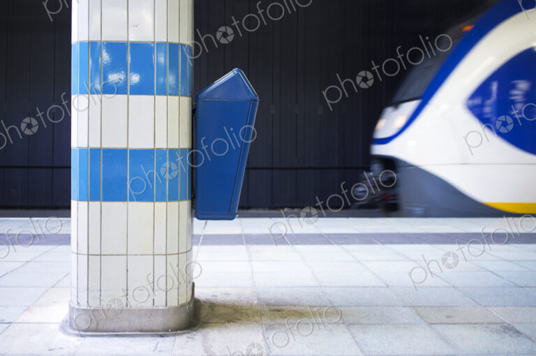Waste bin on a platform pillar in a railway station.