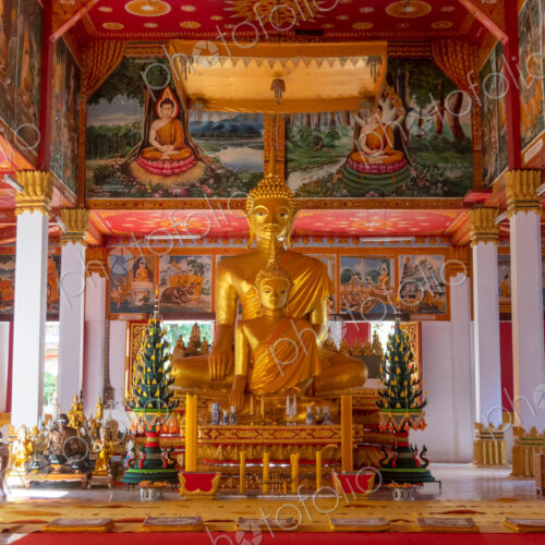 Wat Si Saket, a large golden Buddha statue and altar with offerings and wall murals,… Wat Si Saket, a large golden Buddha statue and altar with offerings and wall murals,…