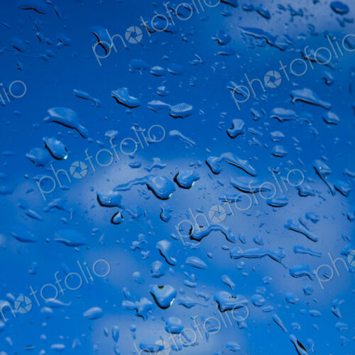 Water droplets on a window, blue background. Water droplets on a window, blue background.