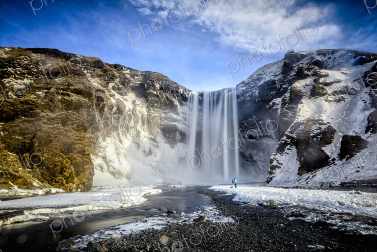 Waterfall pouring over icy cliffs in remote landscape