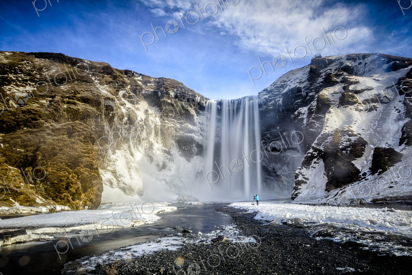 Waterfall pouring over icy cliffs in remote landscape