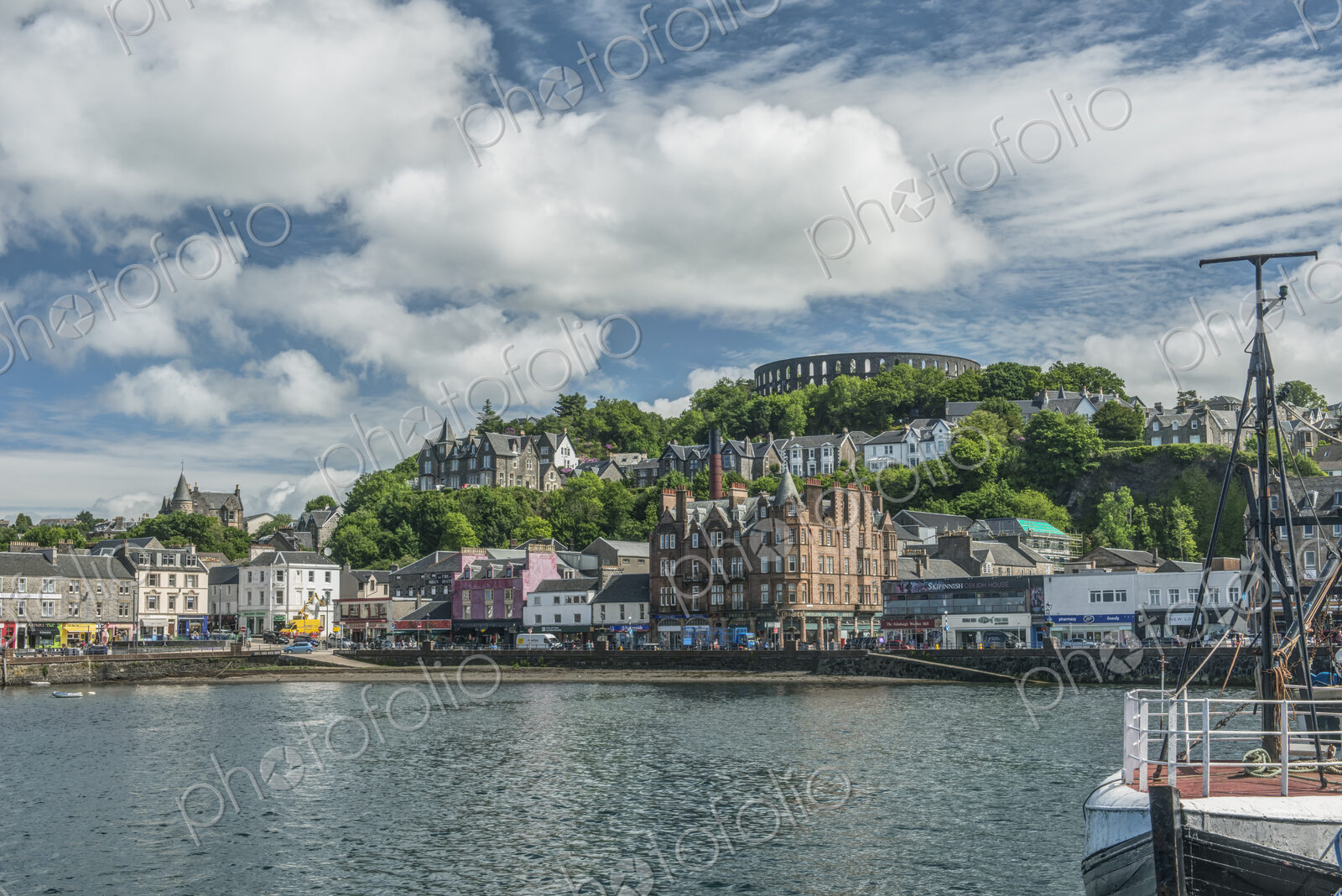 Waterfront town with Coliseum-style monument on hilltop, Mccaig’s Tower and Battery.