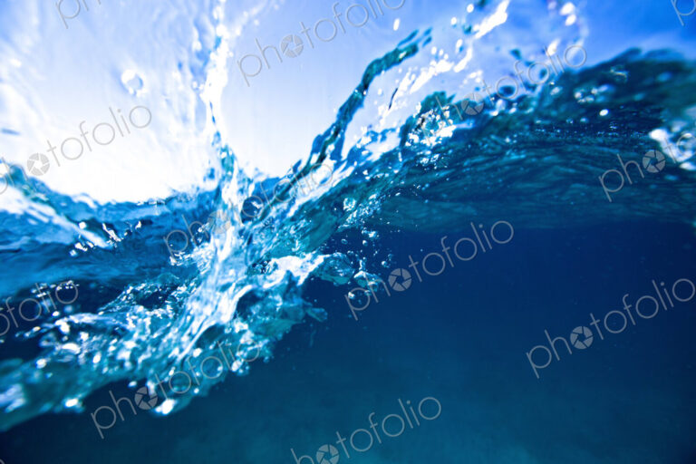 Wave splashing on the camera lens, an over under view.