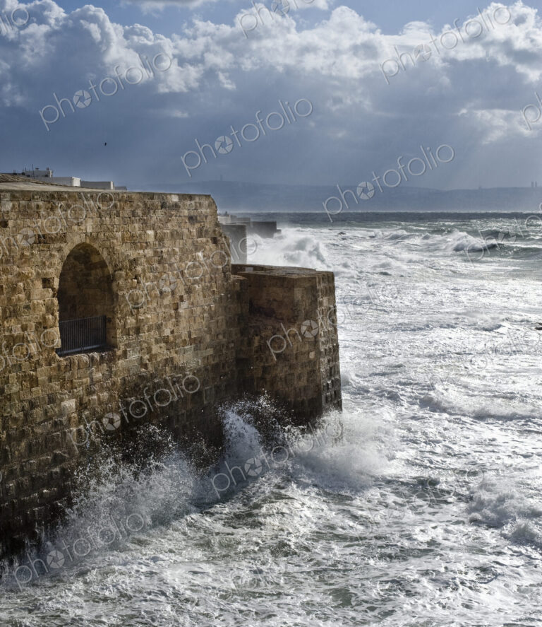 Waves Breaking Against Ancient Walls During A Storm