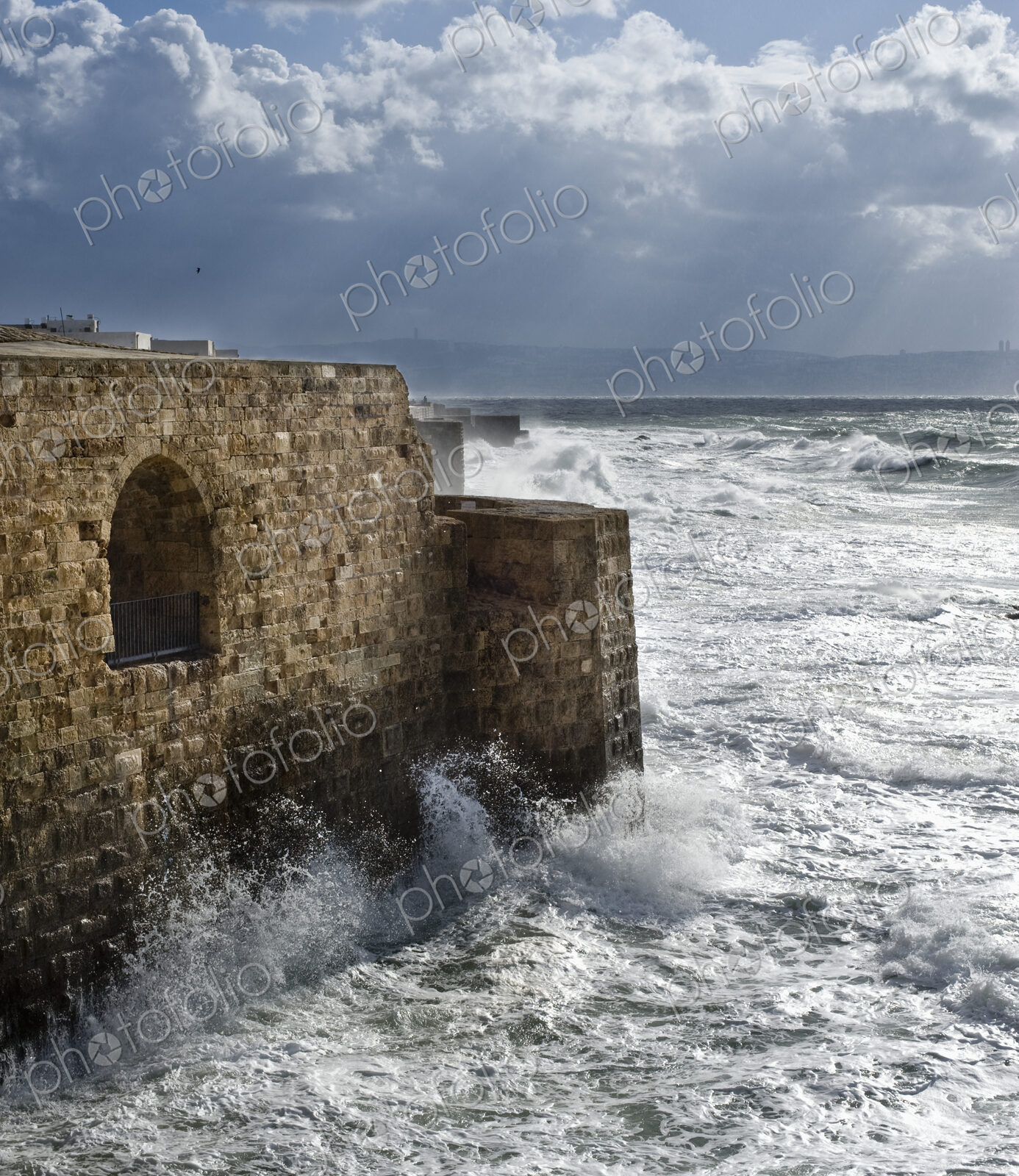 Waves Breaking Against Ancient Walls During A Storm