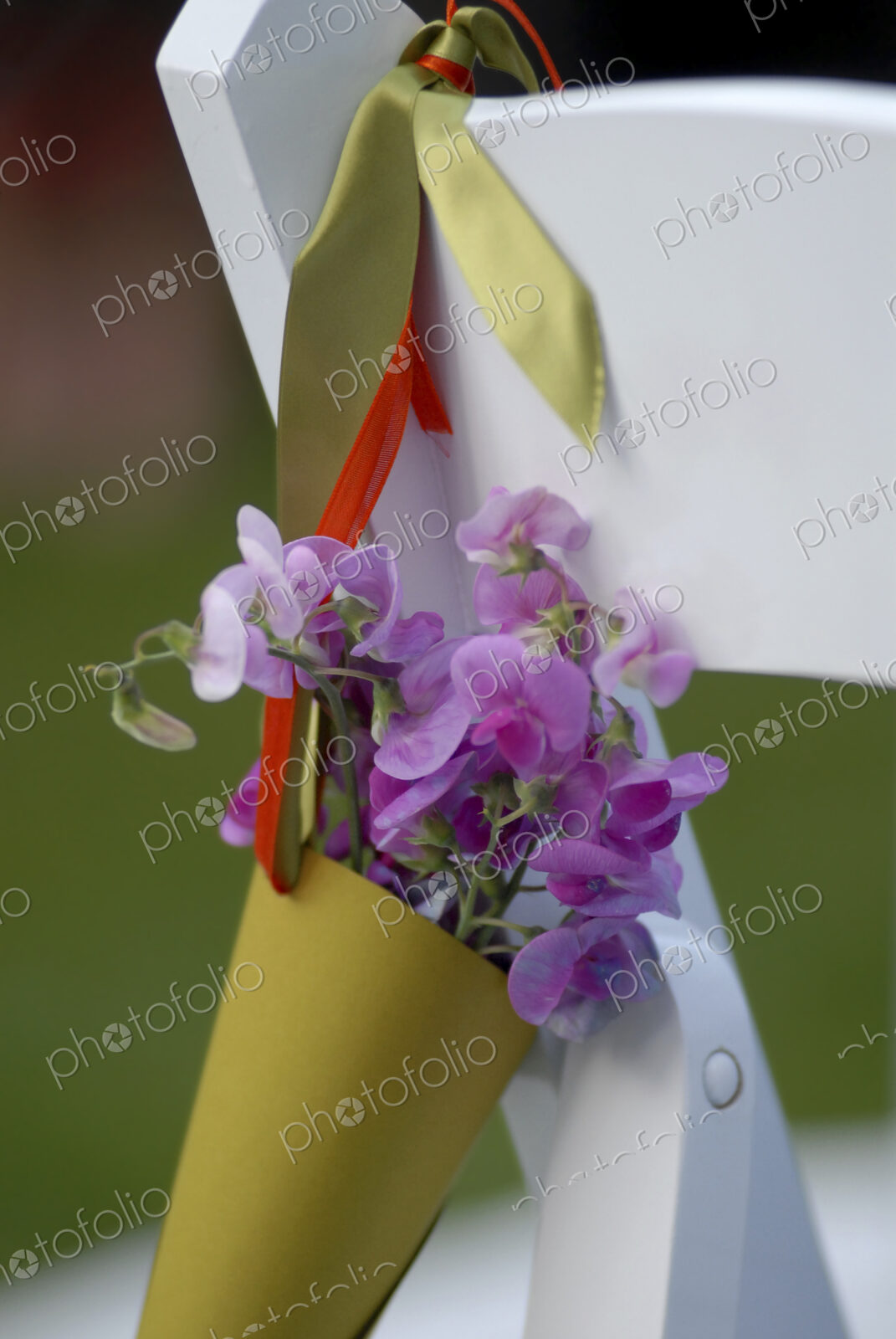 Wedding party chair, a paper cone of lavender coloured sweet peas.