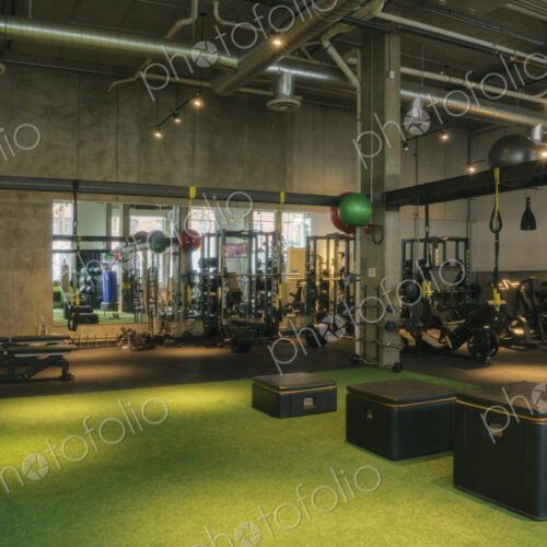 Weights room and exercise equipment in an empty gym.