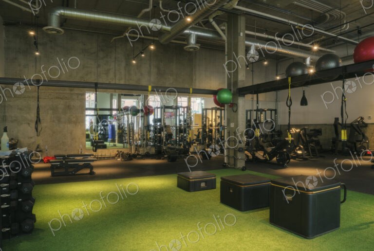 Weights room and exercise equipment in an empty gym.