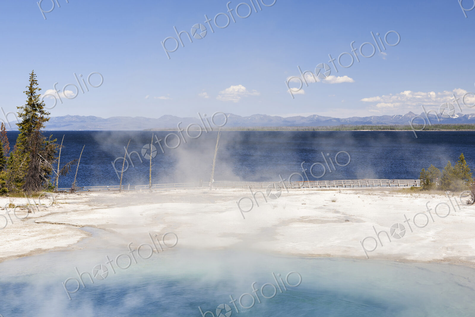 West Thumb geyser basin, a volcanic spring, steam rising from the water.