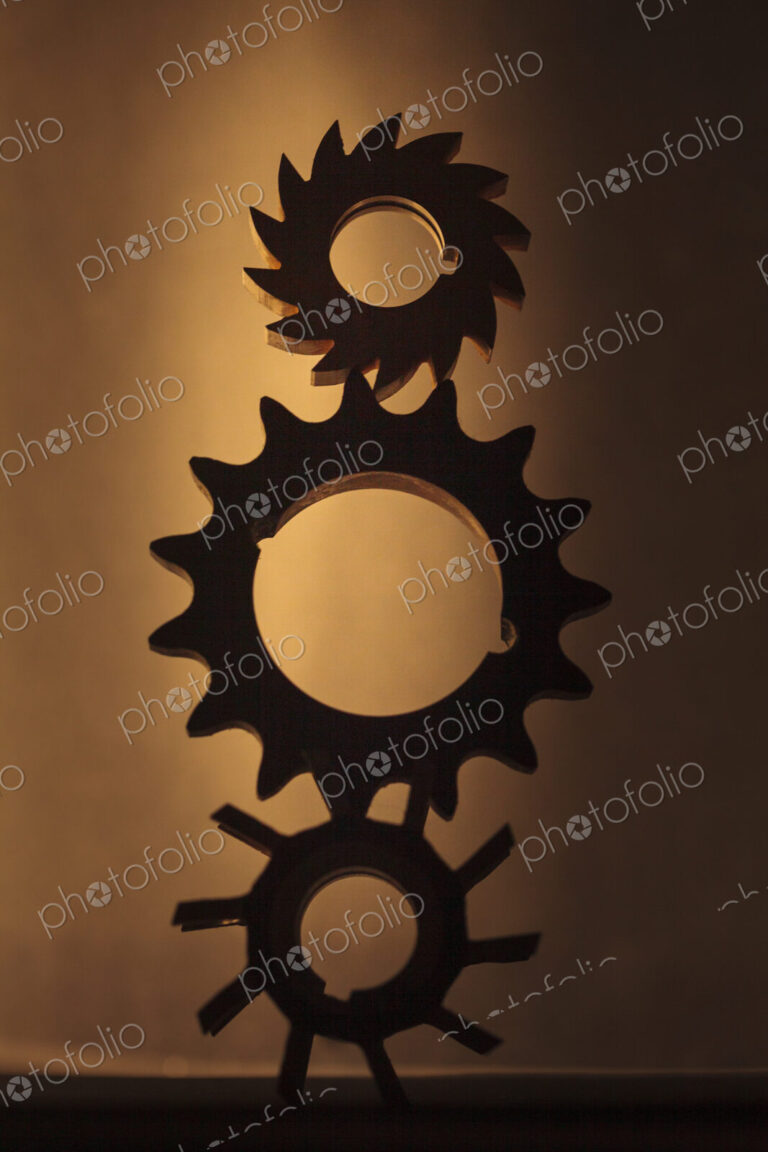 Wheels as gears, a balanced stack of three different metal cog wheels with different…