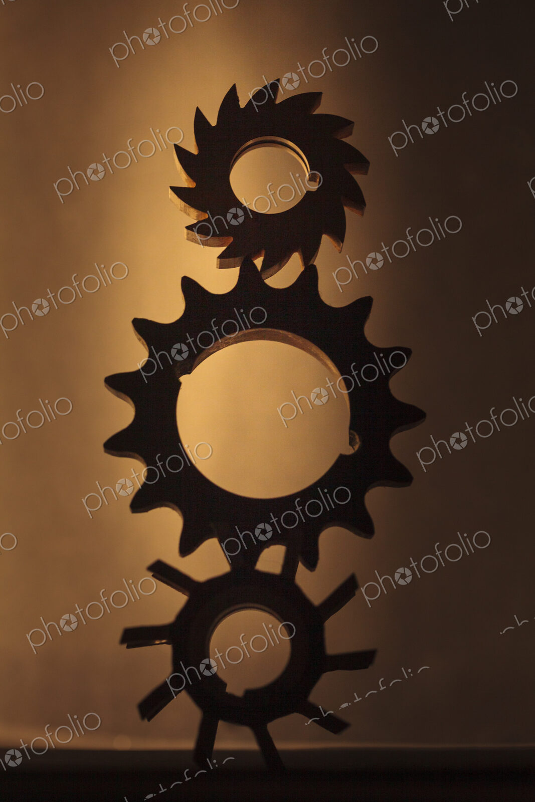 Wheels as gears, a balanced stack of three different metal cog wheels with different…