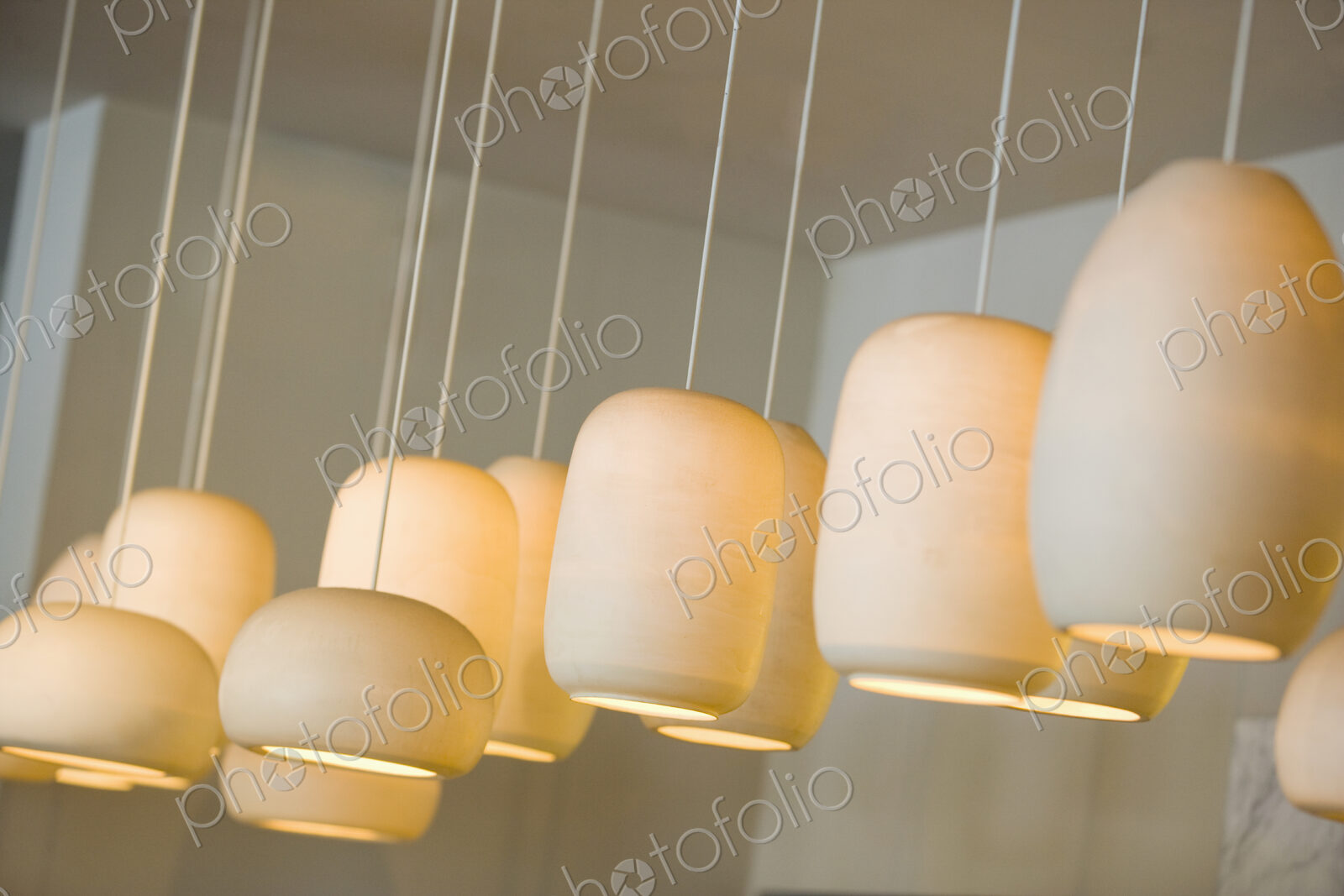 White Lighting Fixtures lit up, hanging in a row
