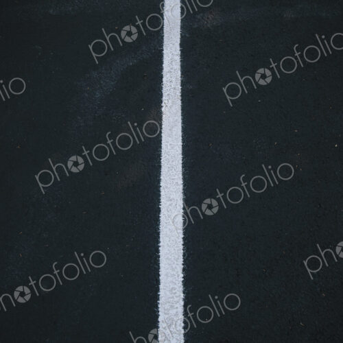 White center line on a black asphalt surface. White center line on a black asphalt surface.