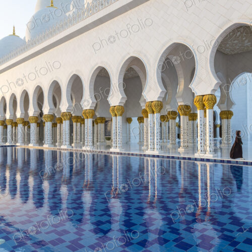 White colonnade of Sheikh Zayed Mosque and blue fountain, Abu Dhabi, United Arab Emirates. White colonnade of Sheikh Zayed Mosque and blue fountain, Abu Dhabi, United Arab Emirates.