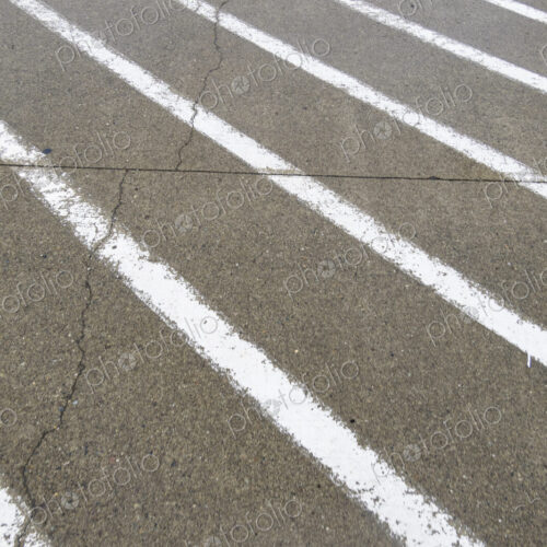 White painted stripes on the asphalt surface of a road. White painted stripes on the asphalt surface of a road.