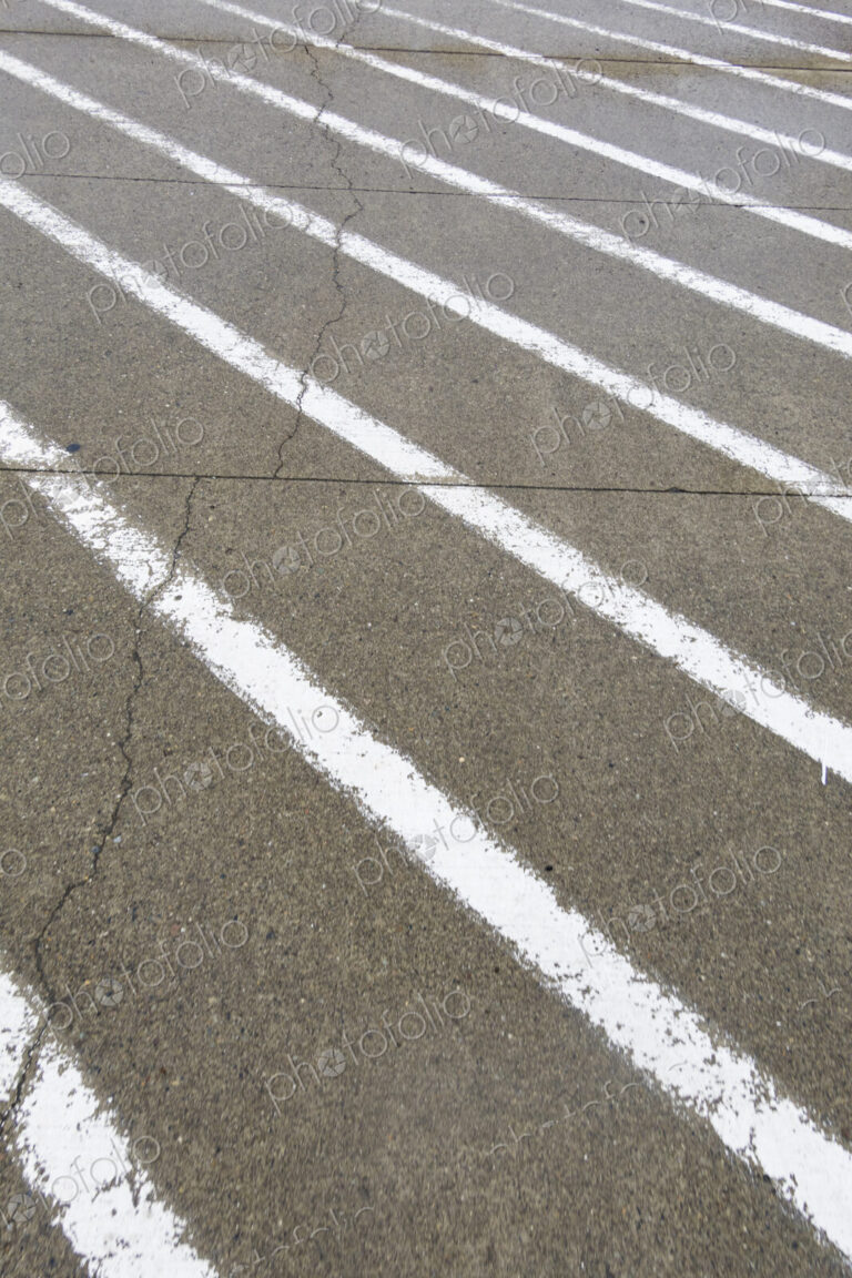 White painted stripes on the asphalt surface of a road.