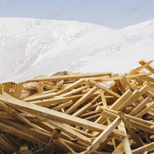 White tarp covering pile of wood 2x4 studs used for construction, near Pullman