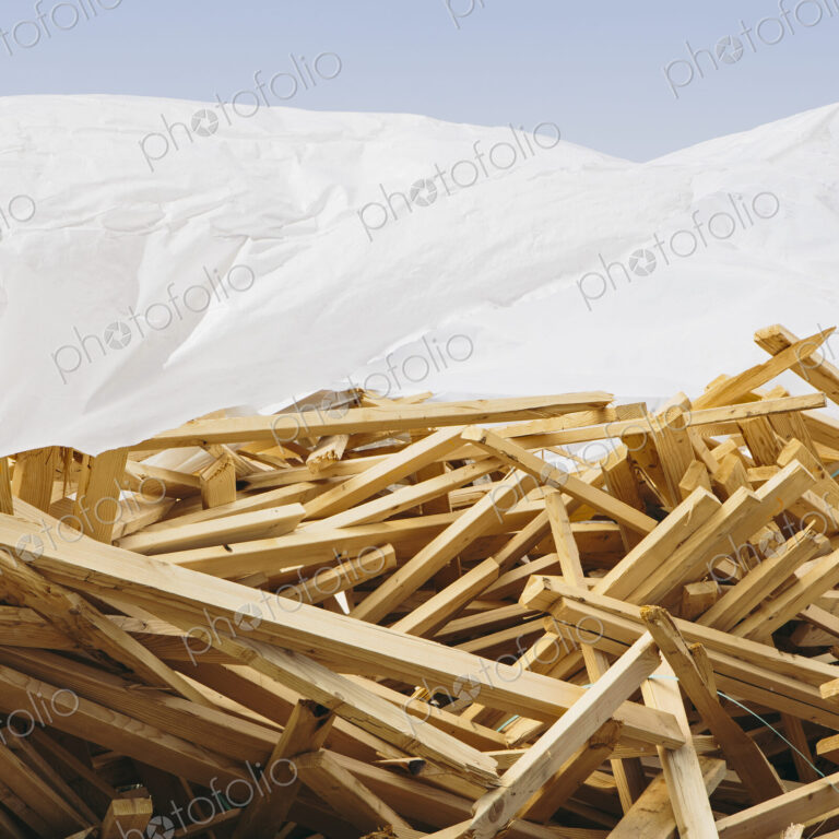 White tarp covering pile of wood 2x4 studs used for construction, near Pullman