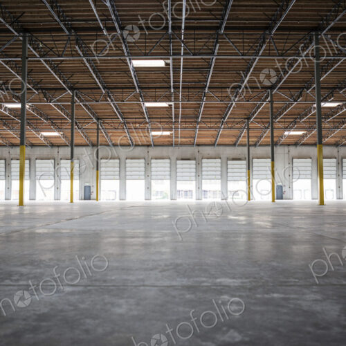 Wide angle interior view of largeempty warehouse and loading dock doors Wide angle interior view of largeempty warehouse and loading dock doors