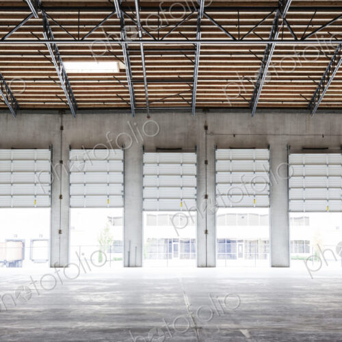 Wide angle interior view of largeempty warehouse and loading dock doors Wide angle interior view of largeempty warehouse and loading dock doors
