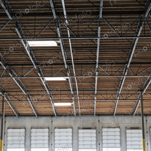 Wide angle interior view of largeempty warehouse and loading dock doors Wide angle interior view of largeempty warehouse and loading dock doors