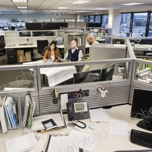 Wide angle view from above looking down on a Mixed Race team of three people working… Wide angle view from above looking down on a Mixed Race team of three people working…