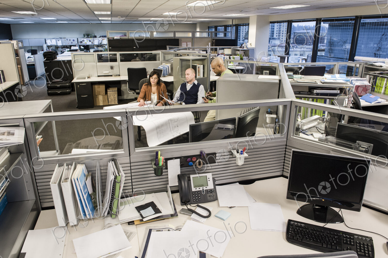 Wide angle view from above looking down on a Mixed Race team of three people working…