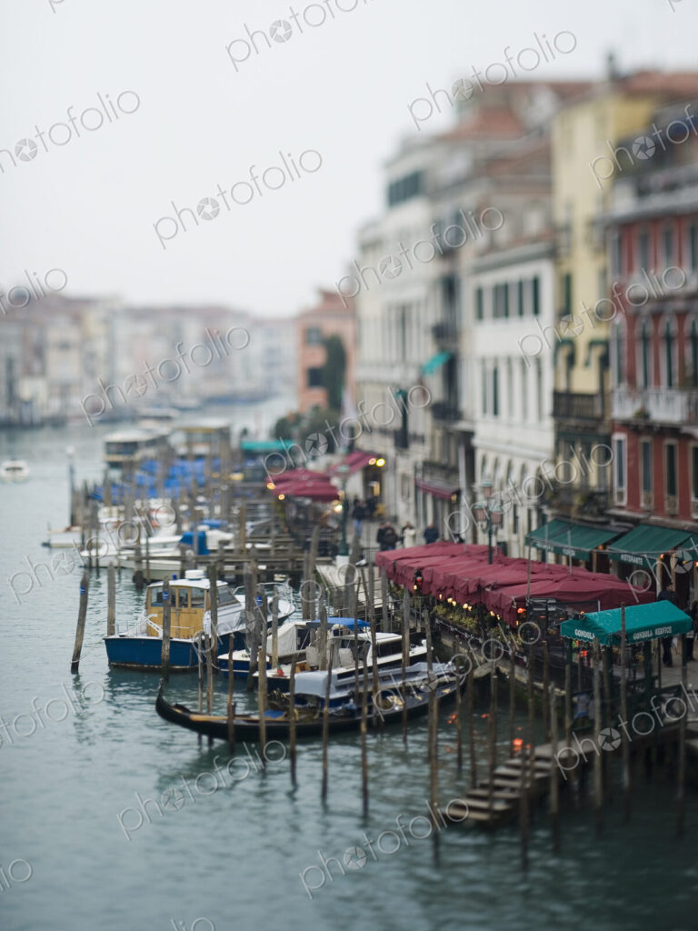 Wide canal in Venice, with boats and traditional gondolas moored