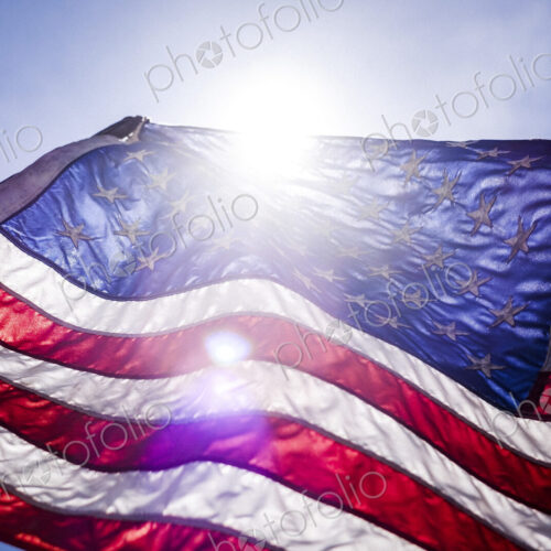 Wind blowing American flag on sunny day Wind blowing American flag on sunny day