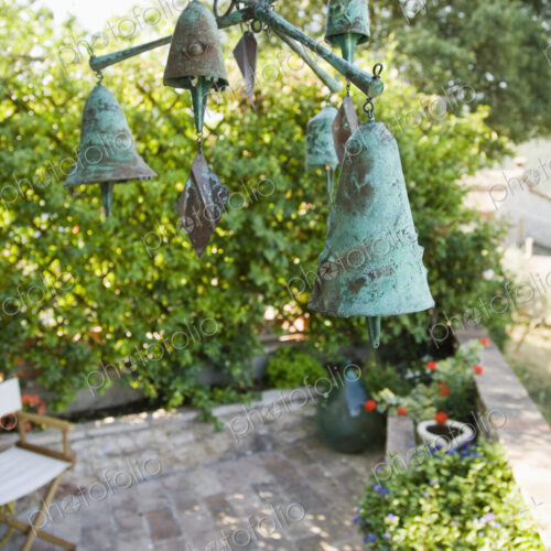 Wind chime or mobile with bronze bells hanging over garden terrace. Wind chime or mobile with bronze bells hanging over garden terrace.