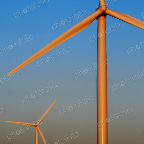 Wind turbines against sunset sky with rising moon Wind turbines against sunset sky with rising moon
