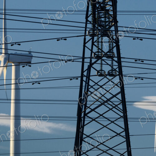 Wind turbines and power lines under blue sky Wind turbines and power lines under blue sky
