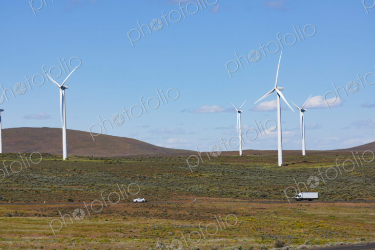 Wind turbines on the rolling hills of Kittikas county in Washington state, tall white…