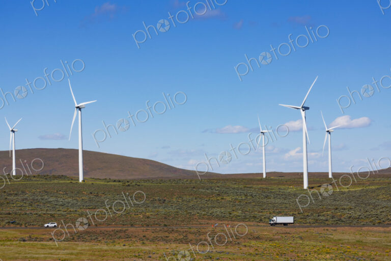Wind turbines on the rolling hills of Kittikas county in Washington state, tall white…