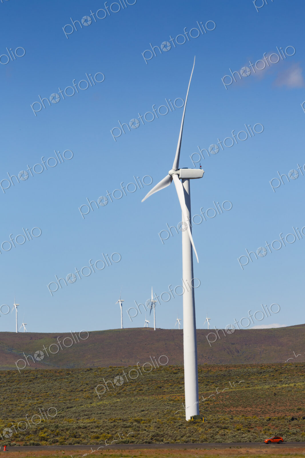 Wind turbines on the rolling hills of Kittikas county in Washington state, tall white…
