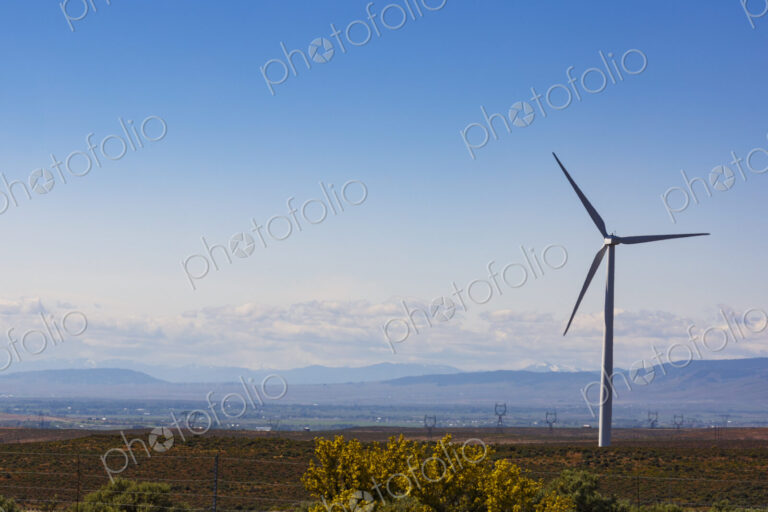 Wind turbines on the rolling hills of Kittikas county in Washington state, tall white…