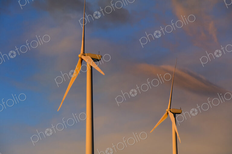 Wind turbines under sunset sky