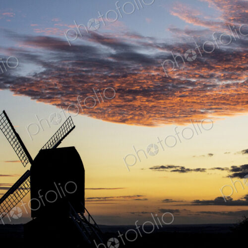 Windmill at sunset under a romantic cloudy sky. Windmill at sunset under a romantic cloudy sky.