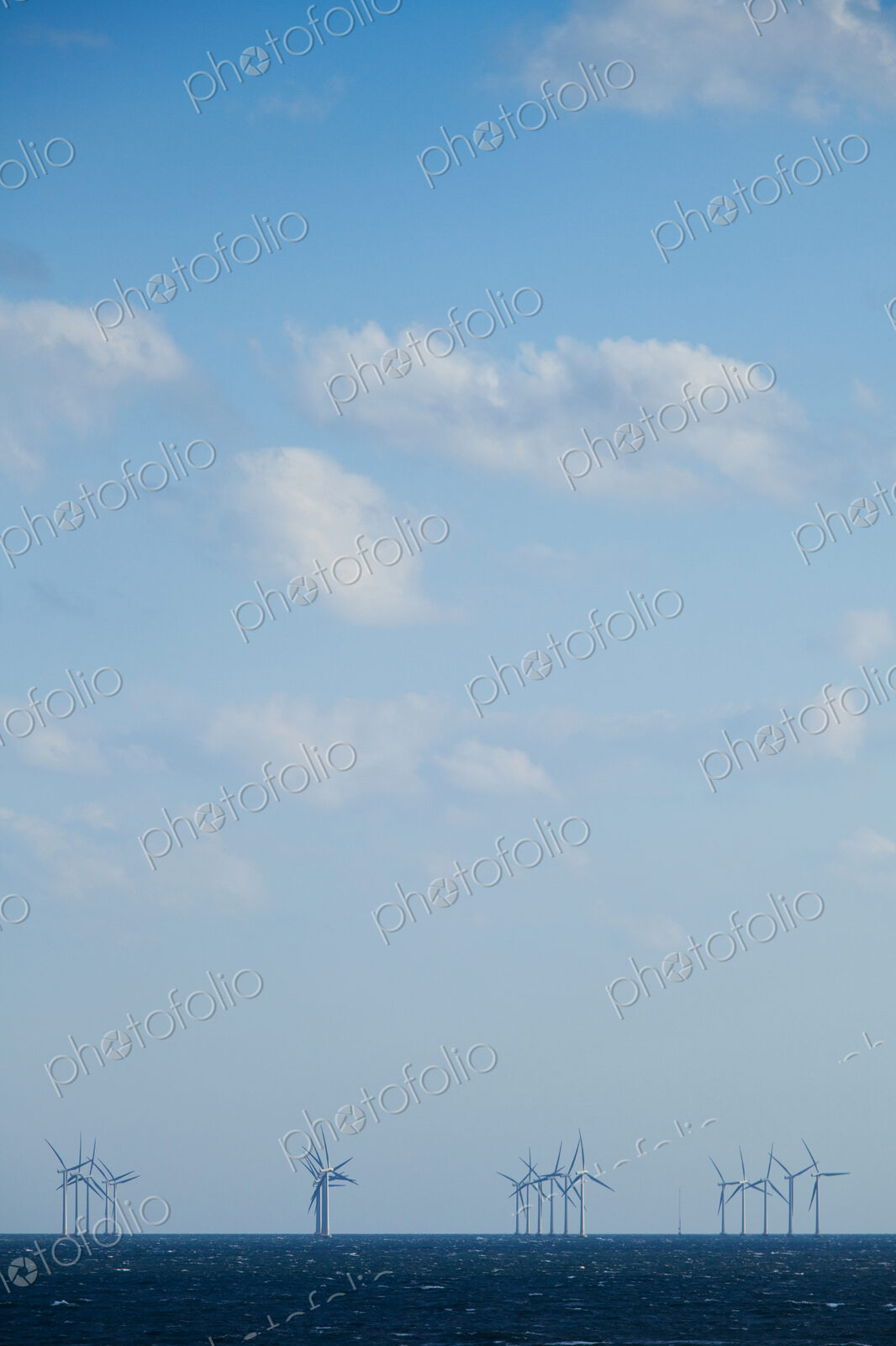 Windmills, turbines in the water in the Oresund Strait on the Baltic sea between…