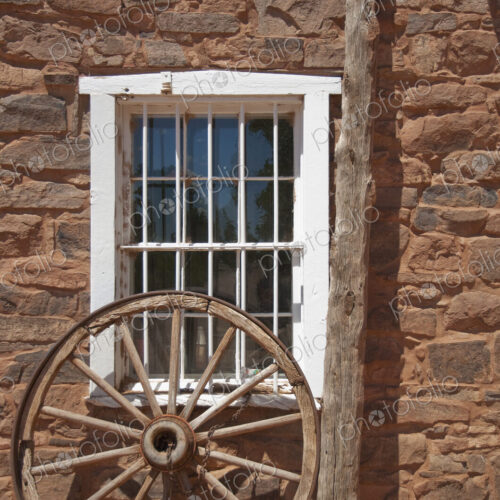 Window in Stone Building With Wagon Wheel