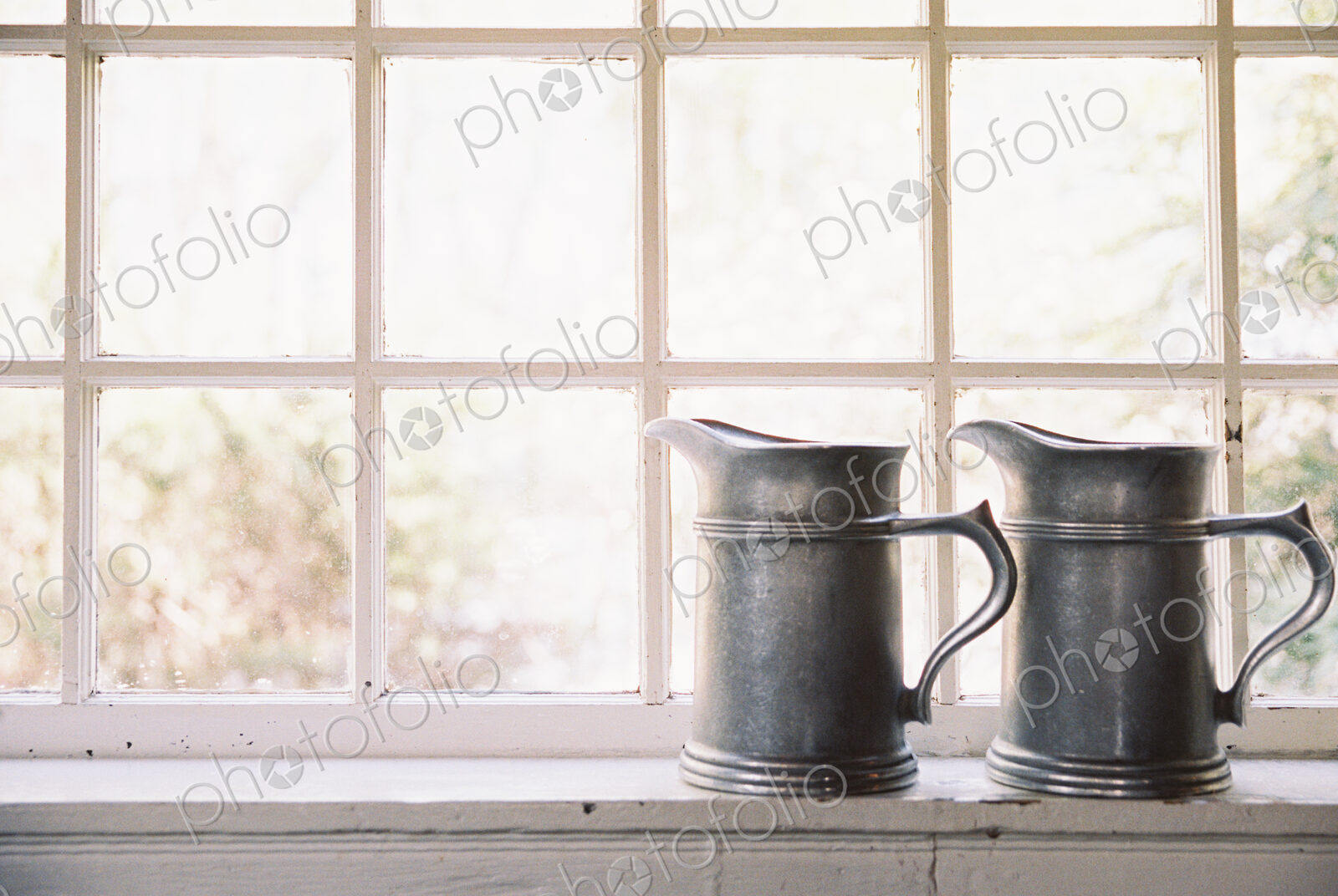 Window in historic house, hotel, two pewter jugs with handles on sill
