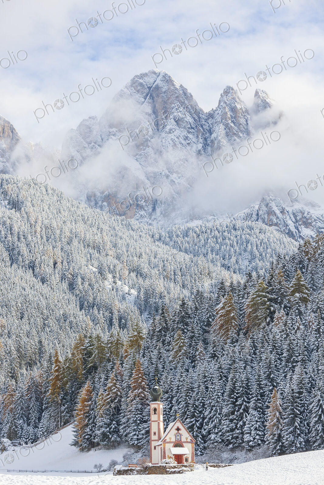 Winter landscape with church, forest and snow-capped mountains.