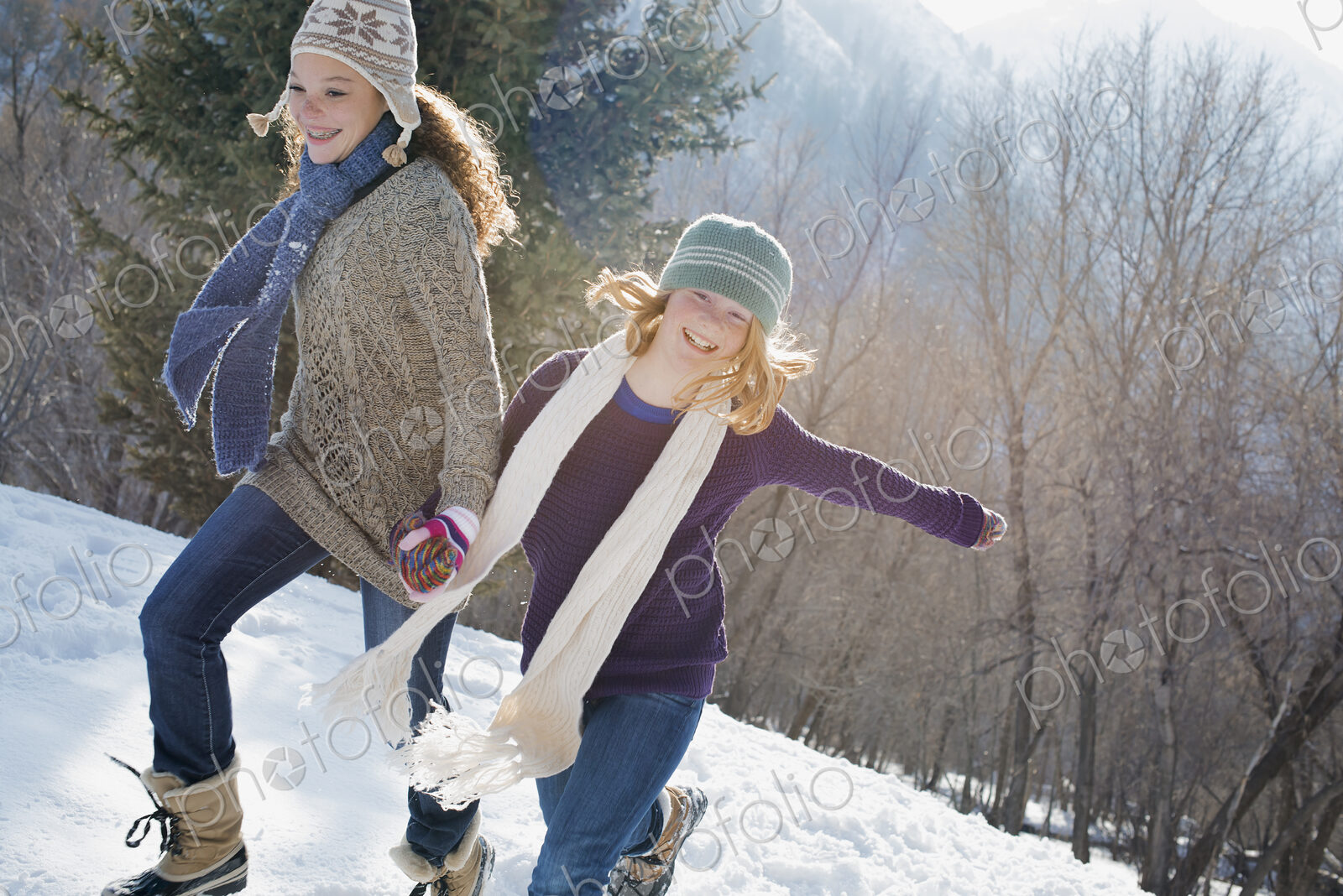 Winter scenery with snow on the ground. A woman and a child hand in hand running…