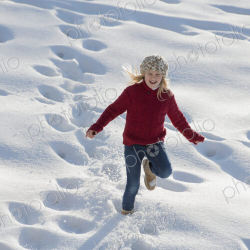 Winter scenery with snow on the ground. A young girl running through deep snow making… Winter scenery with snow on the ground. A young girl running through deep snow making…