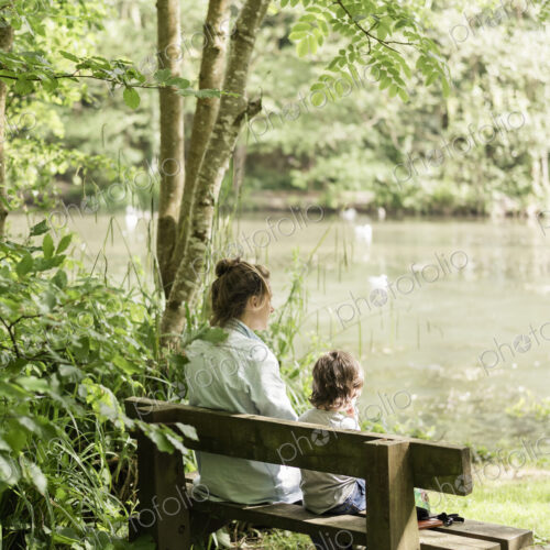 Woman and child sitting on a bench.