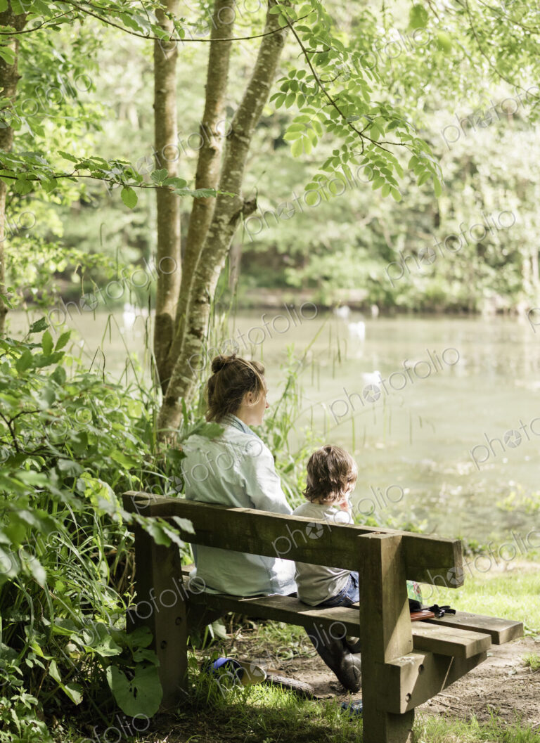 Woman and child sitting on a bench.