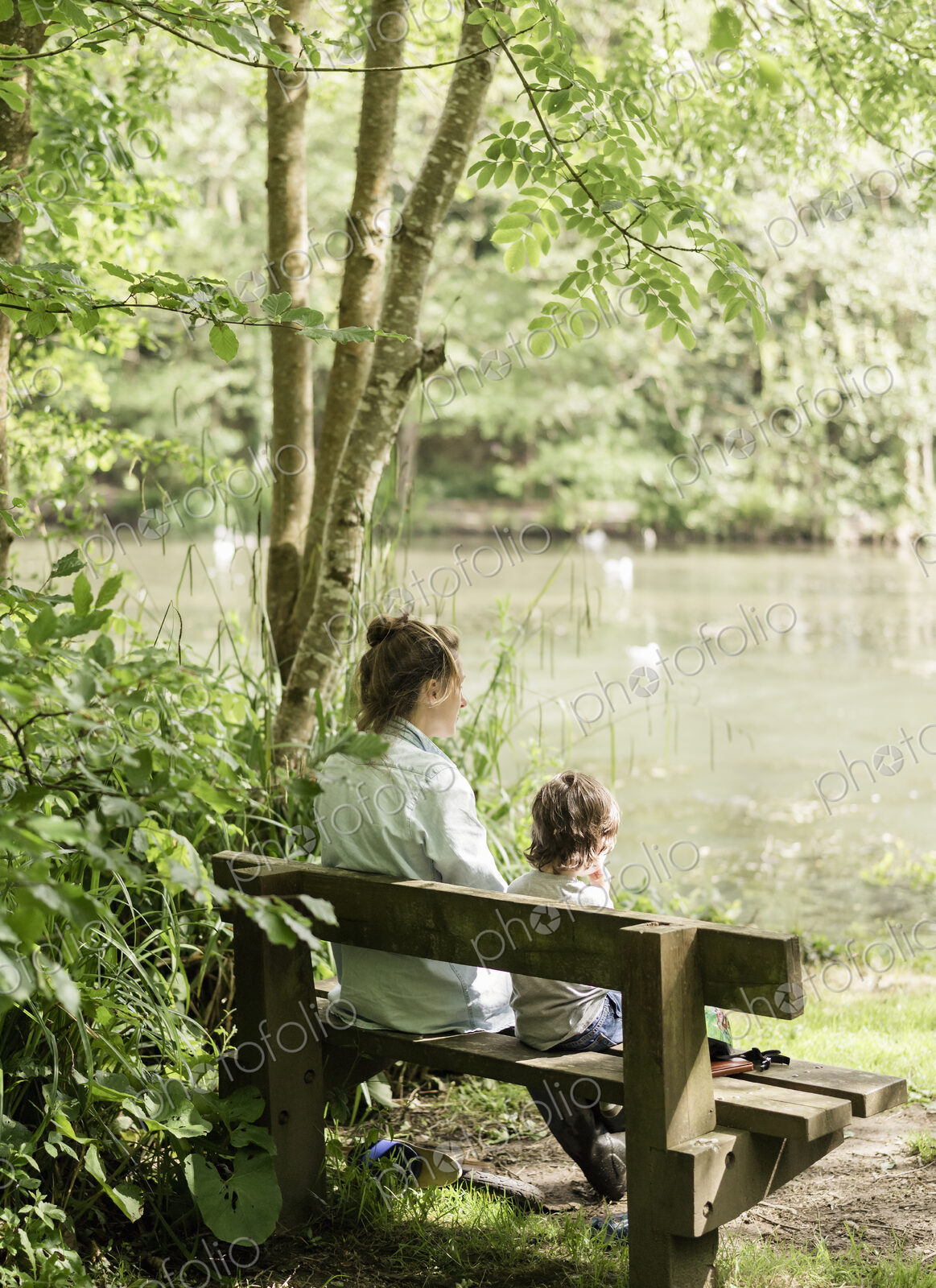 Woman and child sitting on a bench.