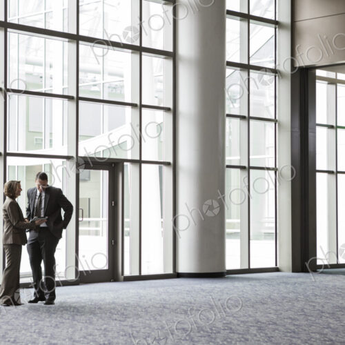 Woman and man in a meeting in a convention center lobby.