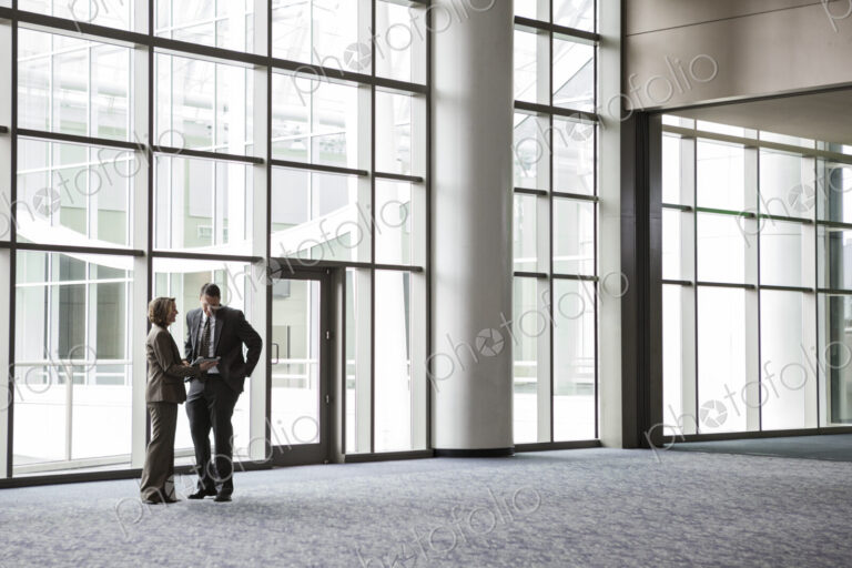 Woman and man in a meeting in a convention center lobby.